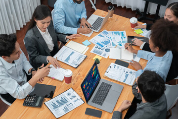 Multiracial analyst team use BI Fintech software to analyze financial data on meeting table....