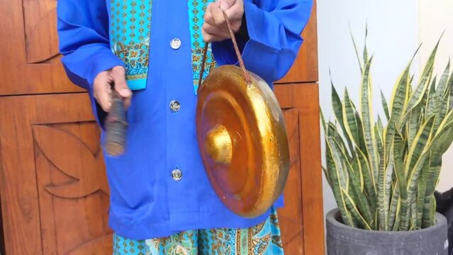 Cinematic shot. A young man of Betawi Tribal Musician playing the traditional instruments famously known as Gambang Kromong