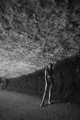 Exploring the mysterious cave man and woman standing together in the dark underground beauty of...