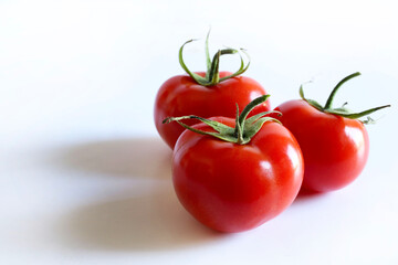 Un gruppo di pomodori freschi isolati su sfondo bianco. Cibo sano e vegetariano. Copia spazio.