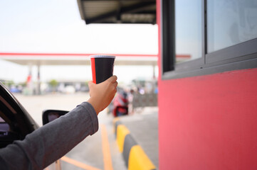 People pick up food and drink glasses from drive-thru counters and take them to eat at home and at...