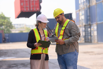 A group of men and women of professional container assemblers stand in a container shipping yard, looking at the preparation of containers. Logistics workers working at containers