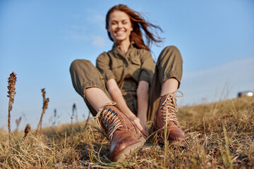 Peaceful field retreat woman resting in nature with blue sky background and boots on