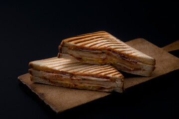 club sandwich on a wooden board on a dark background