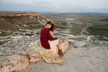 Adventurous woman contemplating majestic valley and mountains on cliff edge for travel and...