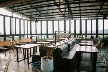 Bogor, Mei 18 2024. Cozy restaurant venue with large glass windows, featuring elegant dining tables and comfortable seating, perfect for a relaxed dining experience