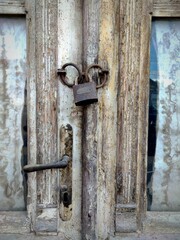 Old Locked Padlock Hanging On The Old Fashioned Grunge Wooden Door.