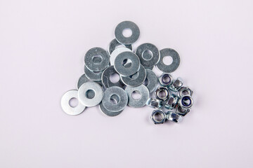 Stack of flat washer and zinc plated hexagon nuts on white background