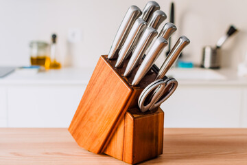 A wooden block with a set of knives in it