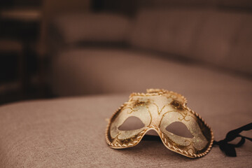A gold mask is on a couch