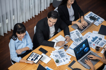 Wide top view of diverse group of business analyst team analyzing financial data report paper on...