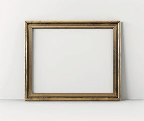 An elegant, empty gold picture frame leaning against a white wall, perfect for showcasing artwork or photography in a minimalist setting..