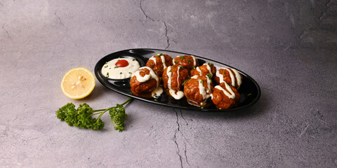 Buffalo Chicken Balls, Deep fried chicken bonded in home made buffalo sauce topped with cheese sauce