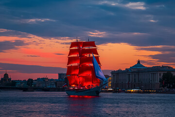 Brig with scarlet sails on the Neva. Fantastic fiery sunset.