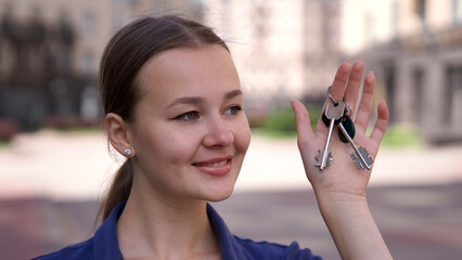 Young woman owner show keys from her new flat in new residential complex