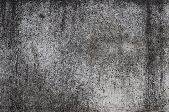 The wall is a rough white surface with black stains on it. Ideas for textured images, chalkboards, free space for text. and decorative patterns