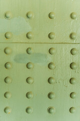 Abstract metallic green background. Old weathered metal background. Vintage metal texture with rivets and bolts. The skin of an old plane. Old metal texture. Vertical photo