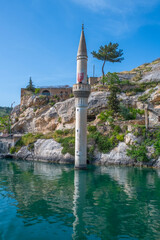 Halfeti village and its submerged minaret and Turkish flags of toursit boats sunken minaret in Halfeti - TURKEY. landscape photo