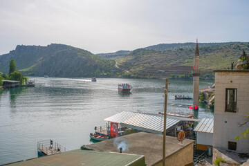 Halfeti village and its submerged minaret and Turkish flags of toursit boats sunken minaret in...