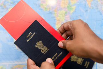 Close up of man hand holding passport and boarding pass on world map background