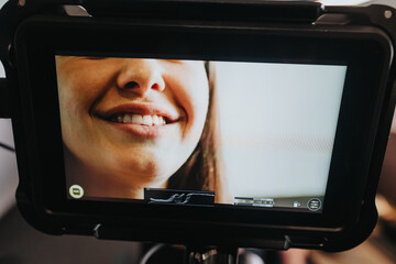 An engaging close-up portrait on a monitor showcasing a woman's smiling face, emphasizing the...