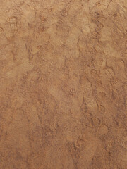 Sand ground textured. Abstract background of wet sand with footprints. Footprints in wet ocher...