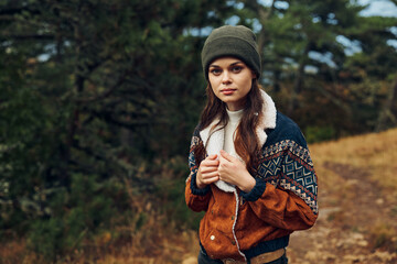 A stylish young woman exploring the tranquil woods on a serene nature walk in her fashionable...