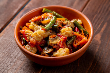 vegetables stewed in spices in a clay bowl on the table