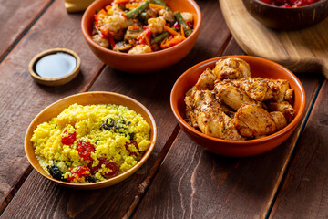 chicken in spices and vegetables stewed on the table next to sesame seeds and soy sauce