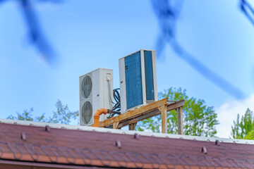 Industrial air conditioning units on a building rooftop against the sky