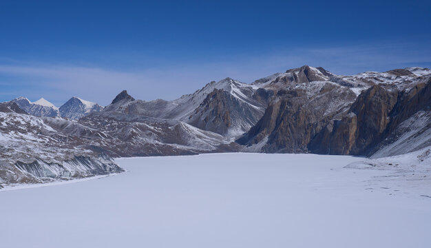 Tilicho lake under ice, Annapurna Conservation area, Himalaya, Nepal. Mountain range in the background. Annapurna Circuit.