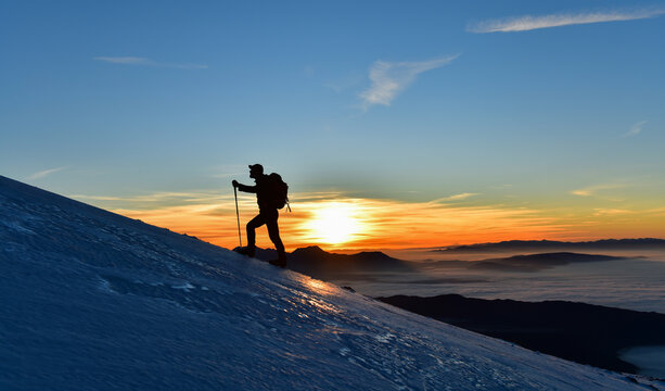 Man Watching Snowy Summit Sunrise