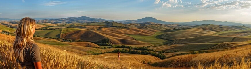 Obraz premium A woman captivated by the serene beauty of rolling green hills.