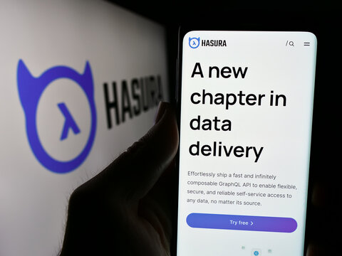 Stuttgart, Germany - 05-07-2024: Person holding cellphone with webpage of US software development company Hasura Inc. in front of logo. Focus on center of phone display.