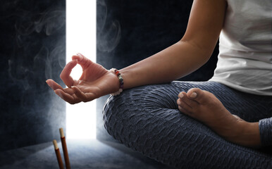 Woman meditating with incense and a passageway that opens
