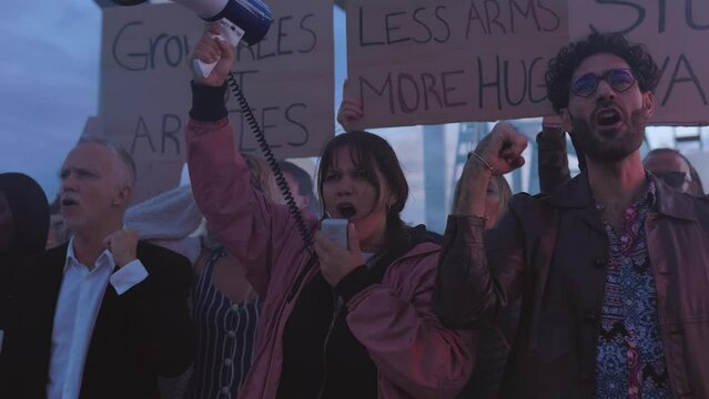 Diverse group of activists people holding posters and banners antiwar protesting against war and violence in the world.