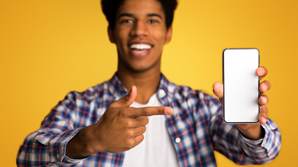 Mockup for advertisement. Guy pointing at blank screen phone over orange background