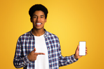 Present new app. Guy pointing at blank screen phone over yellow background