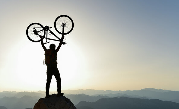 Mountain Biker Lifting Bike Summit