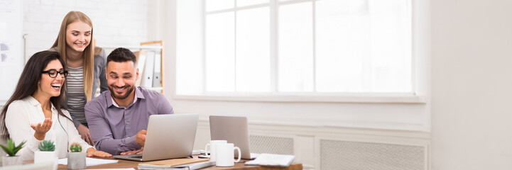 Satisfied business team working on laptop together, having good news, copy space. Teamwork,...