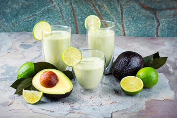 Traditional fruit smoothie with avocado, tropical juices and yoghurt served as close-up on a design stone board