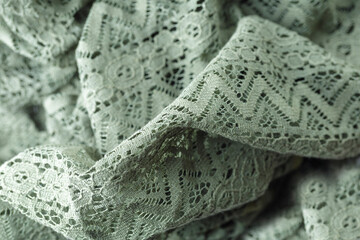 A green knit blanket with a pattern of zigzags. The blanket is soft and cozy, perfect for snuggling up on a cold day