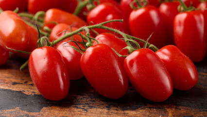 Delicious mini San Marzano tomatoes in wooden background. Organic