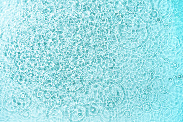 Water surface is adorned with an array of water droplets, creating dynamic and refreshing visual effect. Droplets catch the light beautifully, forming intricate textures that evoke a sense of purity.