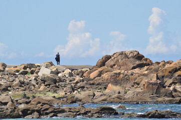 Male person walking and watching the sea, on a sea wall, moment of relaxation and relaxation
