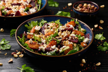 Warm baked carrots and beetroot salad with feta cheese and roasted hazelnuts