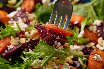 Warm baked carrots and beetroot salad with feta cheese and roasted hazelnuts