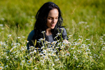 Summer woman face. Pretty girl in a field of daisies. Sensual Woman in a field of summer flowers. Outdoor portrait of girl with a bouquet of daisies. Summer tender female face. Summer daisy.