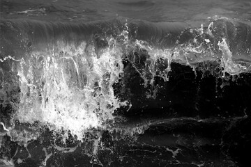 This black-and-white photo captures the dynamic energy of a wave crashing