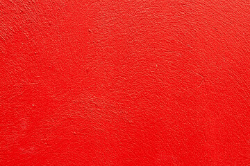 Wall background painted in red color. Solid colored concrete wall texture.